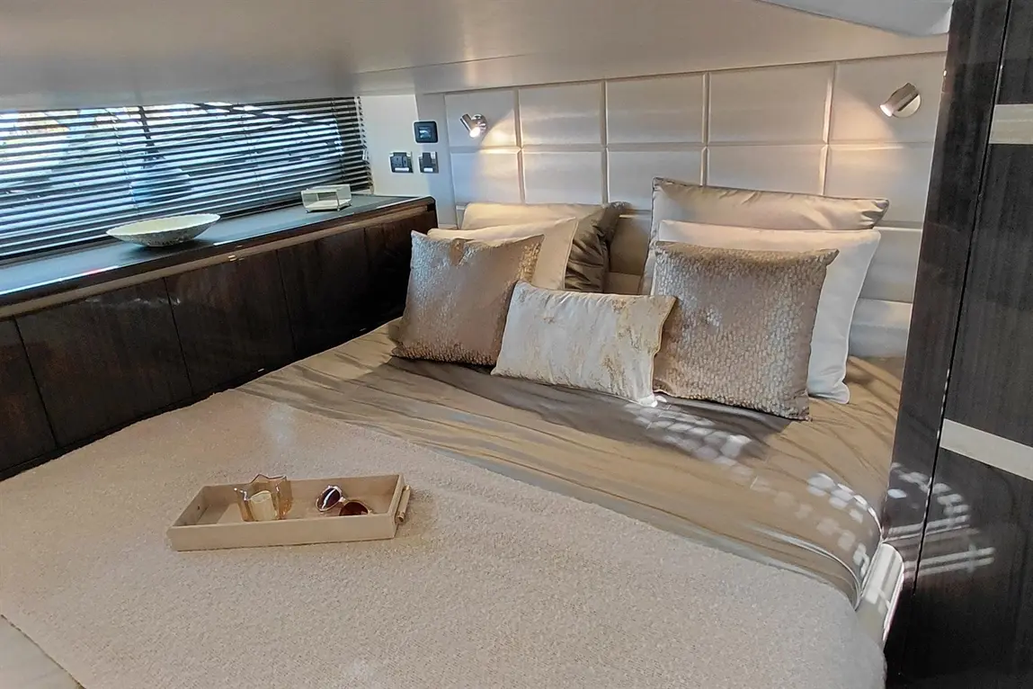Luxurious bedroom featuring a large bed adorned with decorative cushions, modern lighting, and a stylish tray on the bed.